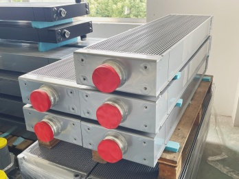 Close-up of aluminum radiator outlets with protective caps before shipment